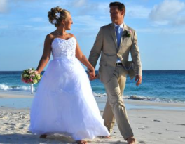 Bride and groom walking on beach after wedding