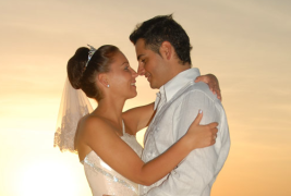 Bride and groom kissing at sunset