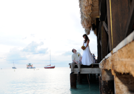 Bride and groom overlooking water at pier